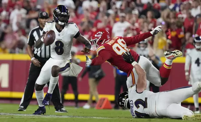 Baltimore Ravens quarterback Lamar Jackson (8) scrambles as Kansas City Chiefs defensive tackle Tershawn Wharton (98) defends during the first half of an NFL football game Thursday, Sept. 5, 2024, in Kansas City, Mo. (AP Photo/Ed Zurga)