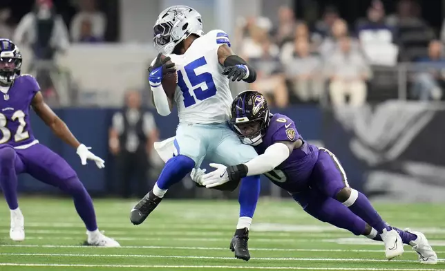 Dallas Cowboys running back Ezekiel Elliott (15) is stopped by Baltimore Ravens linebacker Roquan Smith (0) in the first half of an NFL football game in Arlington, Texas, Sunday, Sept. 22, 2024. (AP Photo/Julio Cortez)