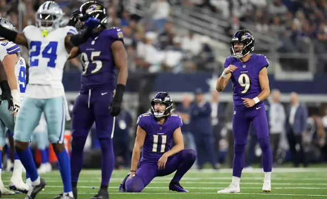 Baltimore Ravens' Jordan Stout (11) looks on as place kicker Justin Tucker (9) reacts to missing on a field goal attempt in the second half of an NFL football game against the Dallas Cowboys in Arlington, Texas, Sunday, Sept. 22, 2024. (AP Photo/Julio Cortez)