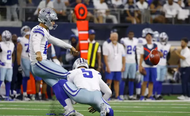 Dallas Cowboys place kicker Brandon Aubrey kicks a 65-yard field goal as punter Bryan Anger (5) holds in the first half of an NFL football game against the Baltimore Ravens in Arlington, Texas, Sunday, Sept. 22, 2024. (AP Photo/Gareth Patterson)