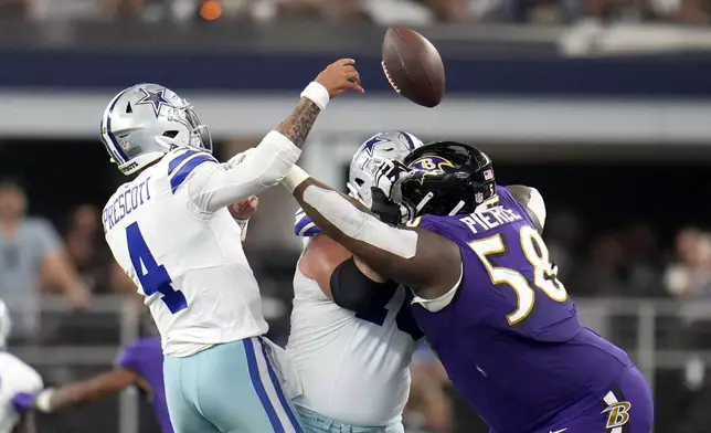 Dallas Cowboys quarterback Dak Prescott (4) is hit trying to throw a pass by Baltimore Ravens defensive tackle Michael Pierce (58) in the second half of an NFL football game in Arlington, Texas, Sunday, Sept. 22, 2024. (AP Photo/Julio Cortez)