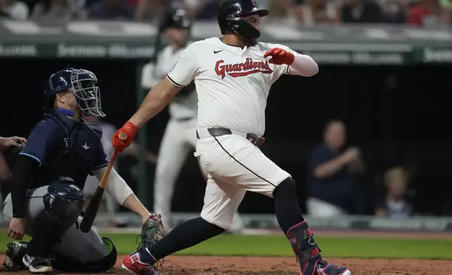 Cleveland Guardians' Josh Naylor, right, hits a single in front of Tampa Bay Rays catcher Logan Driscoll, left, in the sixth inning of a baseball game Saturday, Sept. 14, 2024, in Cleveland. (AP Photo/Sue Ogrocki)