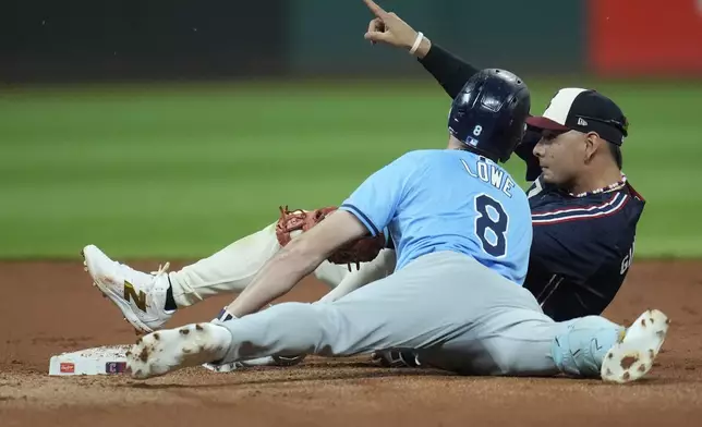 Cleveland Guardians second baseman Andres Gimenez, left, gestures after tagging out Tampa Bay Rays' Brandon Lowe (8) in the fifth inning of a baseball game, Friday, Sept. 13, 2024, in Cleveland. (AP Photo/Sue Ogrocki)