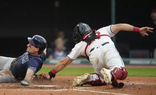 Tampa Bay Rays' Josh Lowe, left, is tagged out by Cleveland Guardians catcher Austin Hedges, right, in the fifth inning of a baseball game Saturday, Sept. 14, 2024, in Cleveland. (AP Photo/Sue Ogrocki)