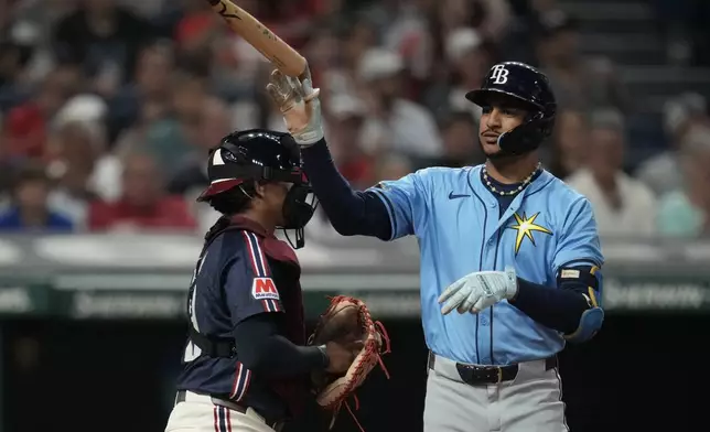 Tampa Bay Rays' Jose Siri tosses his bat after striking out in the sixth inning of a baseball game against the Cleveland Guardians, Friday, Sept. 13, 2024, in Cleveland. Guardians catcher Bo Naylor is at left. (AP Photo/Sue Ogrocki)