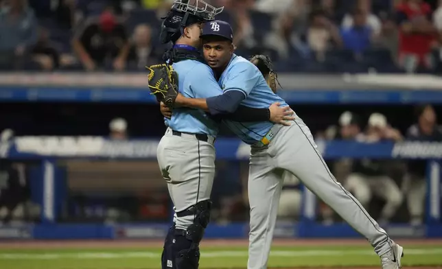 Tampa Bay Rays catcher Logan Driscoll, left, celebrates with relief pitcher Edwin Uceta, right, after they defeated the Cleveland Guardians in a baseball game Friday, Sept. 13, 2024, in Cleveland. (AP Photo/Sue Ogrocki)