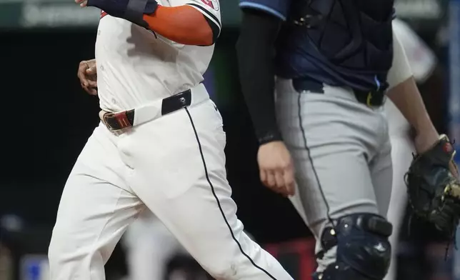 Cleveland Guardians' Jose Ramirez, left, scores behind Tampa Bay Rays catcher Logan Driscoll, right, in the sixth inning of a baseball game Saturday, Sept. 14, 2024, in Cleveland. (AP Photo/Sue Ogrocki)