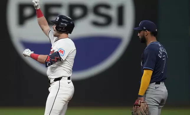 Cleveland Guardians' Lane Thomas, left, gestures from second base in front of Tampa Bay Rays second baseman Jose Caballero (7) after hitting a double in the sixth inning of a baseball game Saturday, Sept. 14, 2024, in Cleveland. (AP Photo/Sue Ogrocki)