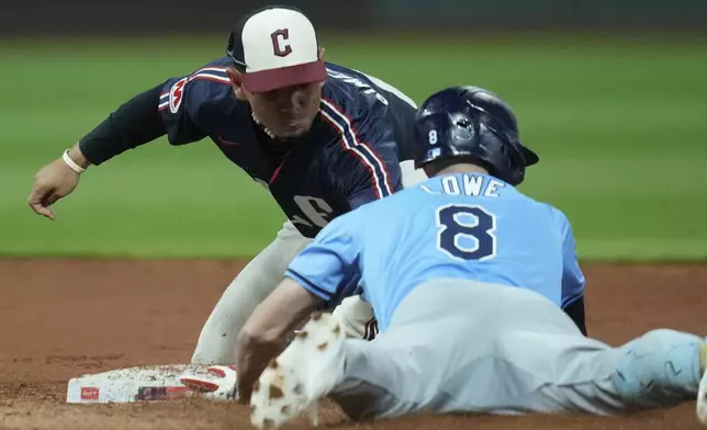 Cleveland Guardians second baseman Andres Gimenez, left, tags out Tampa Bay Rays' Brandon Lowe (8) in the fifth inning of a baseball game, Friday, Sept. 13, 2024, in Cleveland. (AP Photo/Sue Ogrocki)