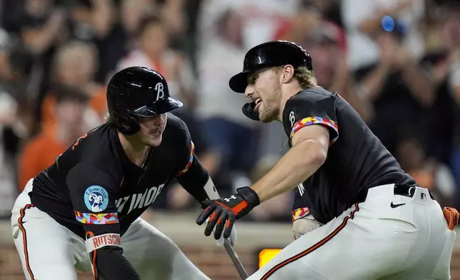 Baltimore Orioles' Gunnar Henderson, right, celebrates with Adley Rutschman, left, after hitting a home run during the sixth inning of a baseball game against the Tampa Bay Rays, Friday, Sept. 6, 2024, in Baltimore. (AP Photo/Stephanie Scarbrough)