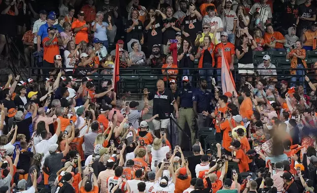 Former Baltimore Orioles player and current team minority owner Cal Ripken Jr., center, is introduced as the guest splasher to spray fans in the "Bird Bath Splash Zone" during a baseball game between the Orioles and the Tampa Bay Rays, Friday, Sept. 6, 2024, in Baltimore. (AP Photo/Stephanie Scarbrough)