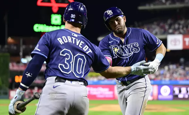 Tampa Bay Rays' Jonathan Aranda, right, high-fives Ben Rortvedt after hitting a solo home run off Philadelphia Phillies' Zack Wheeler during the sixth inning of a baseball game, Wednesday, Sept. 11, 2024, in Philadelphia. (AP Photo/Derik Hamilton)