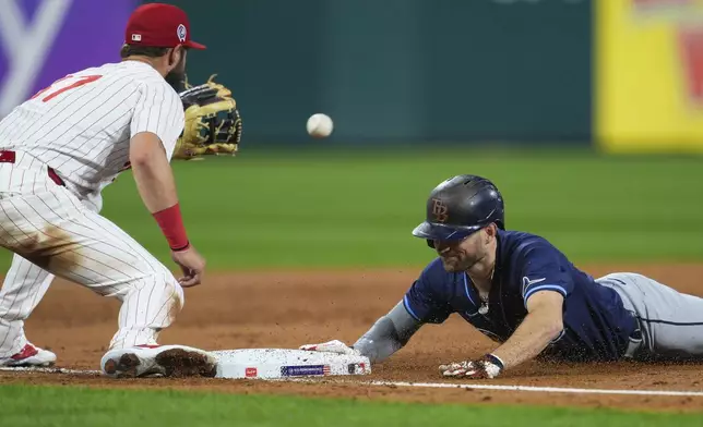 Tampa Bay Rays' Brandon Lowe, right, slides past Philadelphia Phillies' Weston Wilson for a triple during the third inning of a baseball game, Wednesday, Sept. 11, 2024, in Philadelphia. (AP Photo/Derik Hamilton)