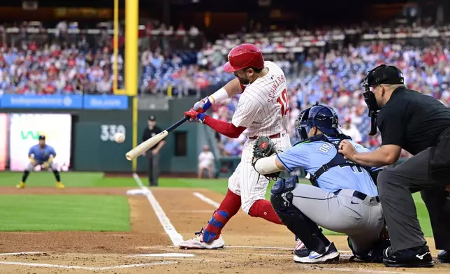 Philadelphia Phillies' Kyle Schwarber, center, hits a solo home run off Tampa Bay Rays' Taj Bradley during the first inning of a baseball game, Tuesday, Sept. 10, 2024, in Philadelphia. (AP Photo/Derik Hamilton)