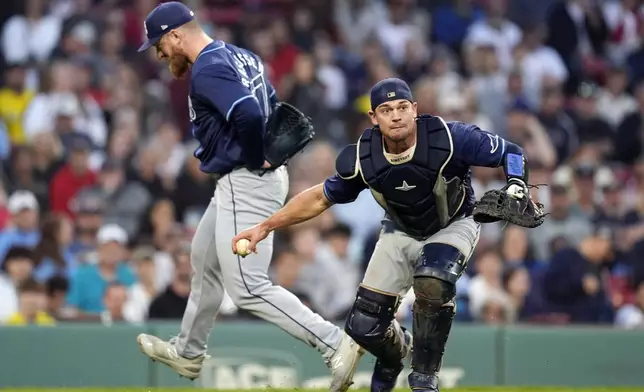 Tampa Bay Rays catcher Ben Rortvedt, right, fields a groundout by Boston Red Sox's Vaughn Grissom in front of relief pitcher Drew Rasmussen, left, during the eighth inning of a baseball game, Saturday, Sept. 28, 2024, in Boston. (AP Photo/Michael Dwyer)