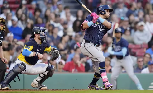 Tampa Bay Rays' Jonathan Aranda, right, follows through on an RBI single in front of Boston Red Sox catcher Danny Jansen, left, during the fifth inning of a baseball game, Saturday, Sept. 28, 2024, in Boston. (AP Photo/Michael Dwyer)