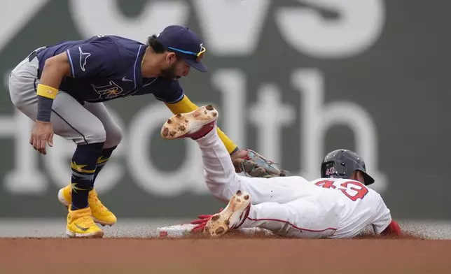 Boston Red Sox's Ceddanne Rafaela, right, slides out at second on a steal attempt as Tampa Bay Rays shortstop Jose Caballero, left, tags him in the fourth inning of a baseball game, Sunday, Sept. 29, 2024, in Boston. (AP Photo/Steven Senne)