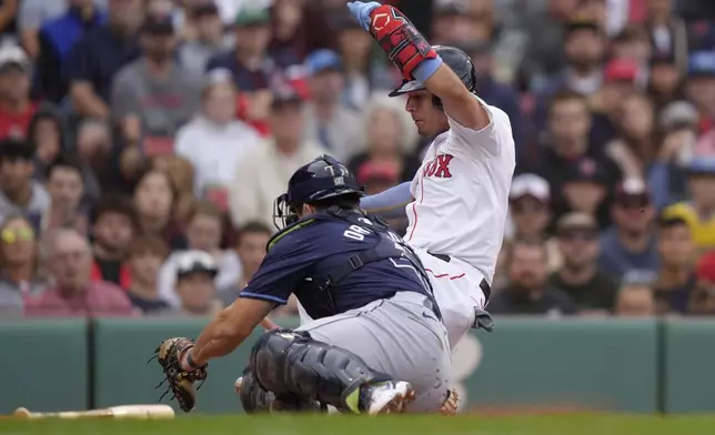 Boston Red Sox's Vaughn Grissom, right, scores in front of Tampa Bay Rays catcher Logan Driscoll, left, after Triston Casas grounded into a fielder's choice in the third inning of a baseball game, Sunday, Sept. 29, 2024, in Boston. (AP Photo/Steven Senne)