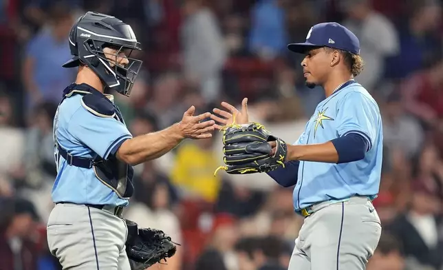 Tampa Bay Rays pitcher Edwin Uceta and catcher Logan Driscoll celebrate after defeating the Boston Red Sox during a baseball game, Friday, Sept. 27, 2024, in Boston. (AP Photo/Michael Dwyer)