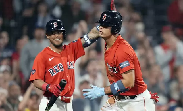 Boston Red Sox's Ceddanne Rafaela, left, reacts as Vaughn Grissom, right, scores on a sacrifice fly by Nick Sogard during the seventh inning of a baseball game against the Tampa Bay Rays, Friday, Sept. 27, 2024, in Boston. (AP Photo/Michael Dwyer)