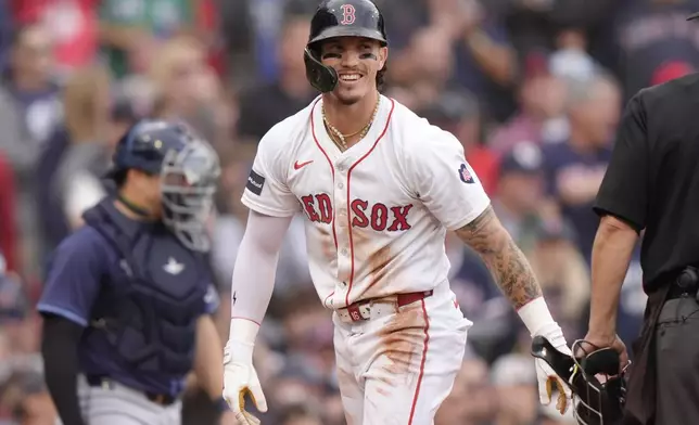 Boston Red Sox outfielder Jarren Duran, center, smiles after scoring on a Tampa Bay Rays error after teammate Vaughn Grissom hit a double in the third inning of a baseball game Sunday, Sept. 29, 2024, in Boston. (AP Photo/Steven Senne)