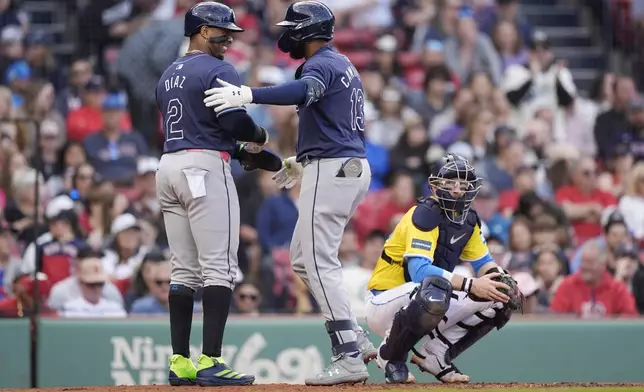 Tampa Bay Rays' Junior Caminero (13) celebrates his two-run home run beside Boston Red Sox catcher Danny Jansen that also drove in Yandy Díaz (2) during the third inning of a baseball game against the Boston Red Sox, Saturday, Sept. 28, 2024, in Boston. (AP Photo/Michael Dwyer)