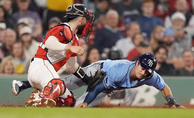 Tampa Bay Rays' Jonny DeLuca is out at home plate against Boston Red Sox catcher Connor Wong while trying to score on a double by Josh Lowe during the seventh inning of a baseball game, Friday, Sept. 27, 2024, in Boston. (AP Photo/Michael Dwyer)