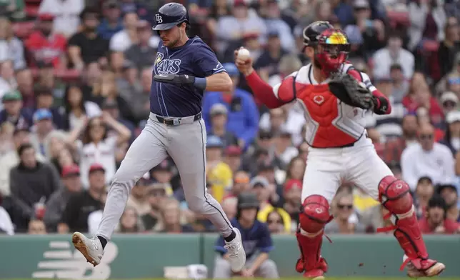 Tampa Bay Rays' Josh Lowe, left, scores on an error in front of Boston Red Sox catcher Connor Wong, right, fourth inning of a baseball game, Sunday, Sept. 29, 2024, in Boston. (AP Photo/Steven Senne)