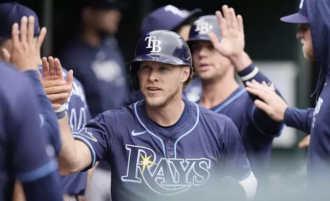 Tampa Bay Rays' Taylor Walls is greeted in the dugout after scoring during the third inning of a baseball game against the Detroit Tigers, Thursday, Sept. 26, 2024, in Detroit. (AP Photo/Carlos Osorio)