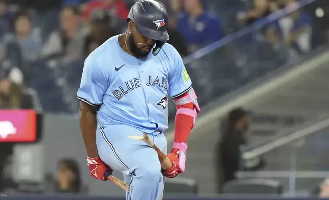 Toronto Blue Jays' Vladimir Guerrero Jr. breaks his bat over his knee after flying out against the Boston Red Sox in the 10th inning of a baseball game in Toronto, Tuesday, Sept. 24, 2024. (Chris Young/The Canadian Press via AP)