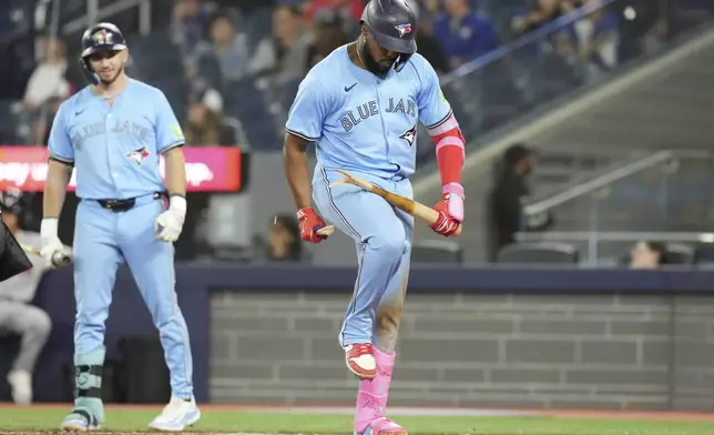 Toronto Blue Jays' Vladimir Guerrero Jr. breaks his bat over his knee after flying out against the Boston Red Sox in the 10th inning of a baseball game in Toronto, Tuesday, Sept. 24, 2024. (Chris Young/The Canadian Press via AP)