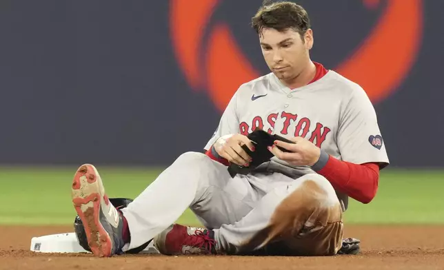 Boston Red Sox' Triston Casas sits at second base after being tagged out in a double play during the fourth inning of a baseball game against the Toronto Blue Jays in Toronto, Tuesday, Sept. 24, 2024. (Chris Young/The Canadian Press via AP)