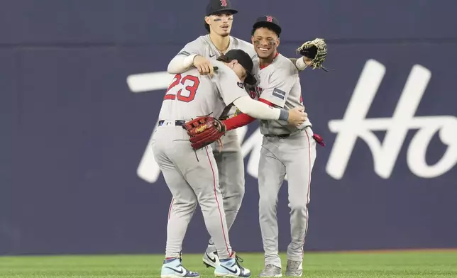 Boston Red Sox's Jarren Duran, center, celebrates with Romy Gonzalez (23) and Ceddanne Rafaela after their team's win over the Toronto Blue Jays in a baseball game in Toronto, Tuesday, Sept. 24, 2024. (Chris Young/The Canadian Press via AP)