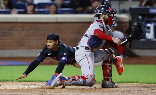 New York Mets' Francisco Lindor, left, scores a runs after beating the throw to Boston Red Sox catcher Connor Wong during the third inning of a baseball game, Monday, Sept. 2, 2024, in New York. (AP Photo/Noah K. Murray)