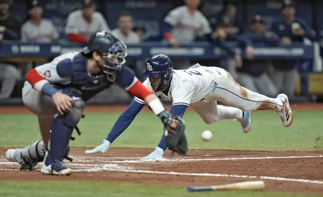 Tampa Bay Rays' Jose Siri, right, scores ahead of the throw to Boston Red Sox catcher Danny Jansen on a sacrifice fly by Brandon Lowe during the third inning of a baseball game Thursday, Sept. 19, 2024, in St. Petersburg, Fla. (AP Photo/Chris O'Meara)