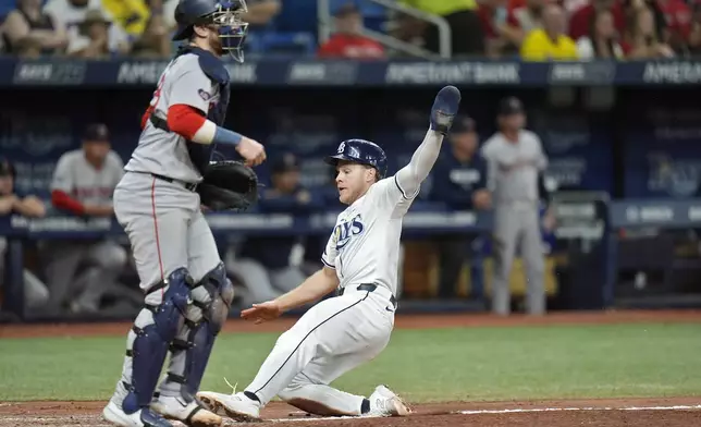 Tampa Bay Rays' Taylor Walls scores in front of Boston Red Sox catcher Danny Jansen on a ground out by Dylan Carlson during the seventh inning of a baseball game Thursday, Sept. 19, 2024, in St. Petersburg, Fla. (AP Photo/Chris O'Meara)