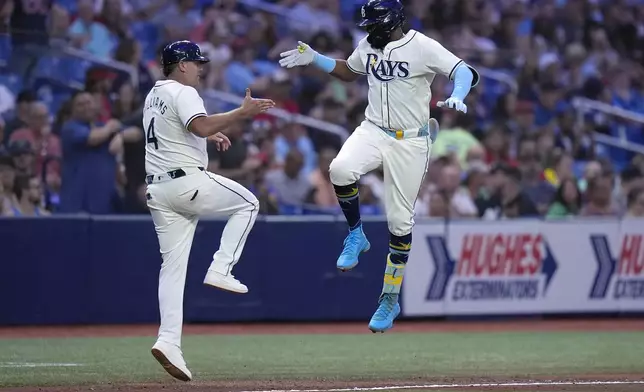 Tampa Bay Rays' Junior Caminero, right, celebrates his solo home run off Boston Red Sox starting pitcher Nick Pivetta with third base coach Brady Williams during the fourth inning of a baseball game Tuesday, Sept. 17, 2024, in St. Petersburg, Fla. (AP Photo/Chris O'Meara)