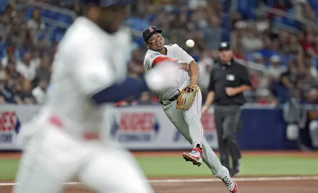 Boston Red Sox third baseman Rafael Devers, right, throws out Tampa Bay Rays' Yandy Diaz at first base on a ground ball during the fifth inning of a baseball game Thursday, Sept. 19, 2024, in St. Petersburg, Fla. (AP Photo/Chris O'Meara)