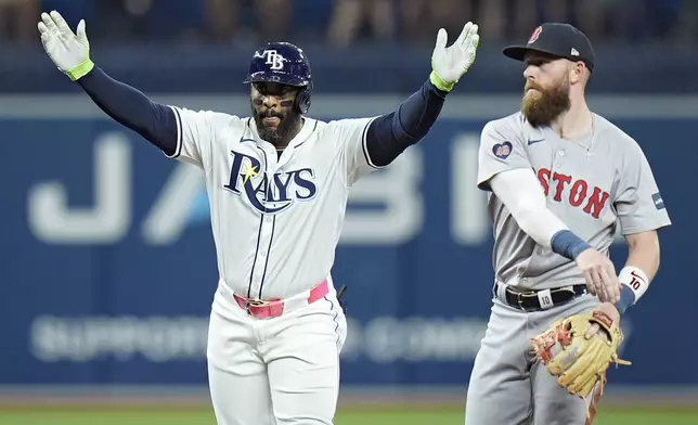 Tampa Bay Rays' Yandy Diaz, left, celebrates after hitting a double off Boston Red Sox starting pitcher Nick Pivetta during the fifth inning of a baseball game Tuesday, Sept. 17, 2024, in St. Petersburg, Fla. Looking on is Boston Red Sox shortstop Trevor Story. (AP Photo/Chris O'Meara)