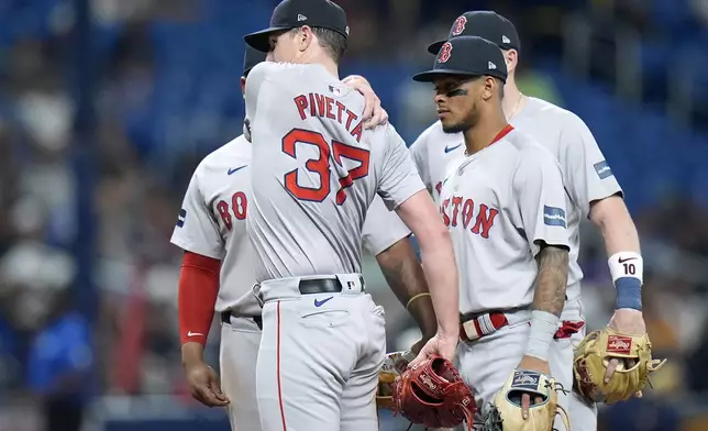 Boston Red Sox starting pitcher Nick Pivetta (37) grabs his shoulder after throwing a pitch to the Tampa Bay Rays during the fifth inning of a baseball game Tuesday, Sept. 17, 2024, in St. Petersburg, Fla. Pivetta stayed in the game. Looking on is second baseman Ceddanne Rafaela. (AP Photo/Chris O'Meara)