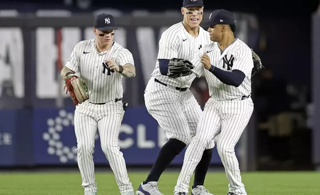 New York Yankees' Aaron Judge, center, Alex Verdugo, left, and Juan Soto, right, celebrate after a baseball game against the Boston Red Sox, Friday, Sept. 13, 2024, in New York. (AP Photo/Adam Hunger)