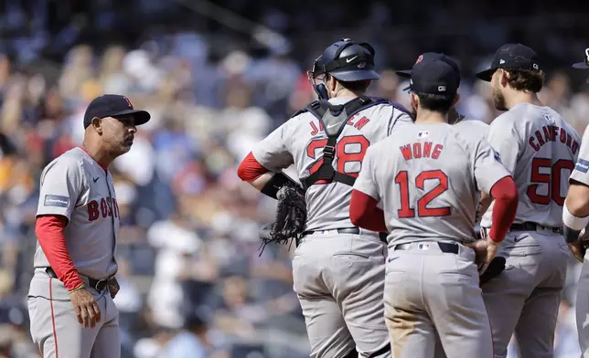 Boston Red Sox manager Alex Cora, left, walks out to take Kutter Crawford (50) out during the fifth inning of a baseball game against the New York Yankees, Sunday, Sept. 15, 2024, in New York. (AP Photo/Adam Hunger)