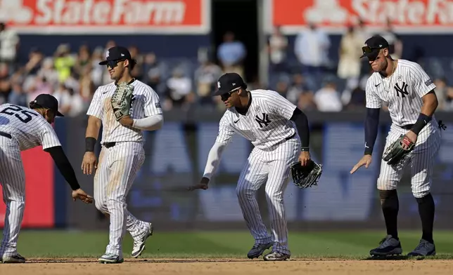 New York Yankees second baseman Gleyber Torres (25) celebrates with Jasson Dominguez, second from left, Juan Soto, second from right, and Aaron Judge, right, after a baseball game against the Boston Red Sox, Sunday, Sept. 15, 2024, in New York. (AP Photo/Adam Hunger)