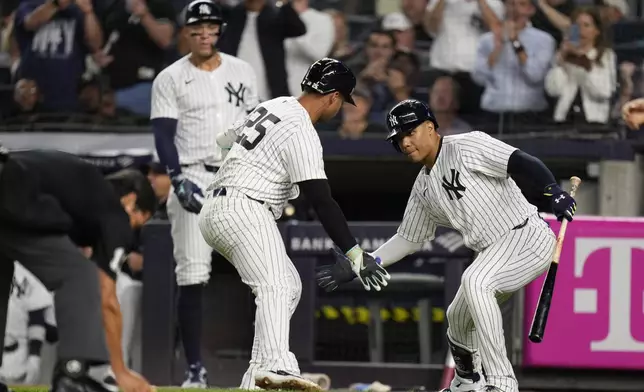 New York Yankees' Gleyber Torres (25), center, celebrates after his home run with Juan Soto, right, during the first inning of a baseball game against the Boston Red Sox at Yankee Stadium, Thursday, Sept. 12, 2024, in New York. (AP Photo/Seth Wenig)