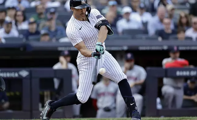 New York Yankees designated hitter Giancarlo Stanton hits a sacrifice fly during the seventh inning of a baseball game against the Boston Red Sox, Sunday, Sept. 15, 2024, in New York. (AP Photo/Adam Hunger)