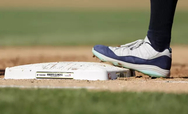 New York Yankees' Aaron Judge stands on first base that is commemorated for Roberto Clemente Day during the fifth inning of a baseball game against the Boston Red Sox, Sunday, Sept. 15, 2024, in New York. (AP Photo/Adam Hunger)