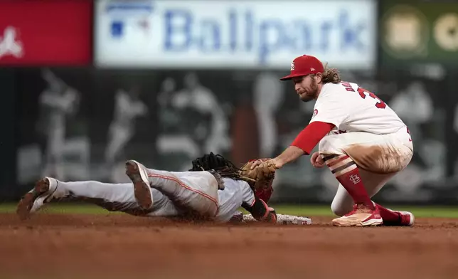 Cincinnati Reds' Elly De La Cruz, left, is caught stealing by St. Louis Cardinals second baseman Brendan Donovan during the third inning of a baseball game Tuesday, Sept. 10, 2024, in St. Louis. (AP Photo/Jeff Roberson)