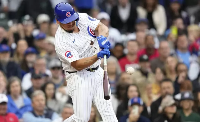 Chicago Cubs' Isaac Paredes hits a pinch-hit RBI single off Cincinnati Reds relief pitcher Justin Wilson during the eighth inning of a baseball game Saturday, Sept. 28, 2024, in Chicago. (AP Photo/Charles Rex Arbogast)