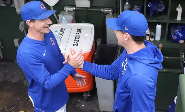 Chicago Cubs manager Craig Counsell, left, congratulates starting pitcher Kyle Hendricks after the team's 3-0 win over the Cincinnati Reds in a baseball game Saturday, Sept. 28, 2024, in Chicago. (AP Photo/Charles Rex Arbogast)