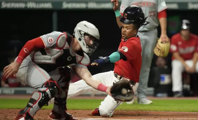 Cleveland Guardians' Jose Ramirez, right, starts his slide into home plate as Cincinnati Reds catcher Tyler Stephenson takes the throw in the fifth inning of a baseball game in Cleveland, Tuesday, Sept. 24, 2024. (AP Photo/Sue Ogrocki)